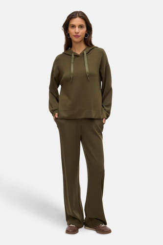 Pull-over vert de VERO MODA avec capuche, complété par un short de jogging coordonné et des chaussures en cuir marron.
