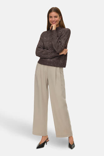 Manteau brun VERO MODA®, avec longues manches, associé à un pantalon beige large et des escarpins noirs.