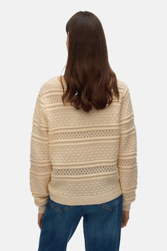 Gilet beige avec col rond de VERO MODA, à motif ajouré et longues manches, porté avec un jean.