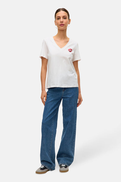 Wit T-shirt met korte mouwen van VERO MODA®, met rode lippenprint en gecombineerd met blauwe jeans.