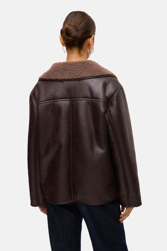 Bruine jas van VERO MODA® met een zachte kraag en donkere jeans, gezien van achteren.
