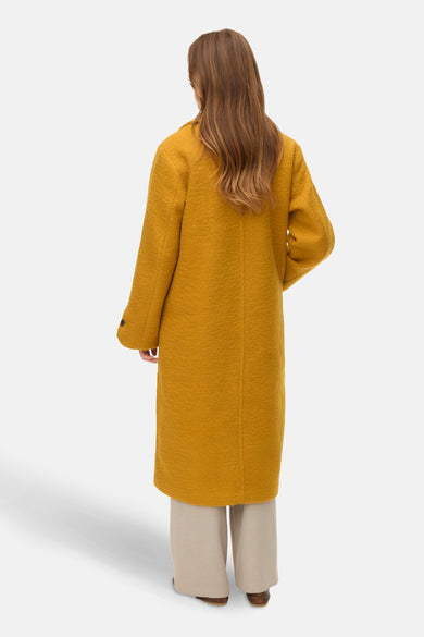 Gele lange jas van VERO MODA®, gezien van achteren, met lange mouwen en een slanke pasvorm.