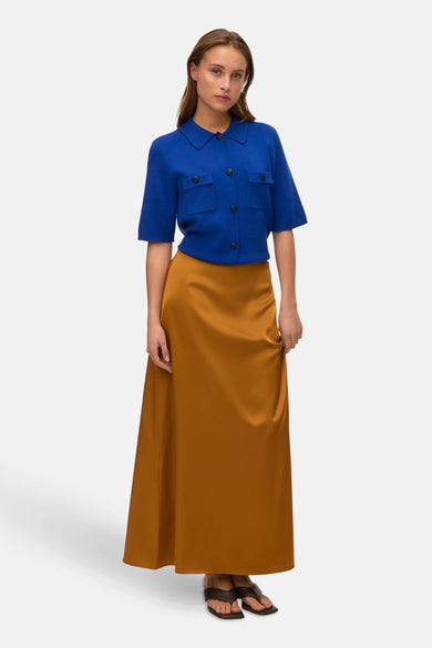 Gouden lange rok van VERO MODA, gecombineerd met een blauwe blouse en sandalen.
