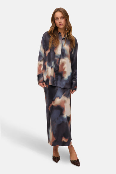 Veelkleurig hemd met lange mouwen van VERO MODA, met abstracte print, gedragen met een lange rok en bruine schoenen.
