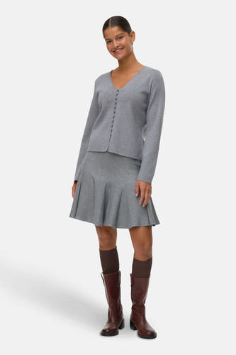 Korte grijze rok van VERO MODA®, gecombineerd met bruine laarzen en donkere sokken.
