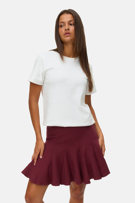 Korte bordeaux rok van VERO MODA, gecombineerd met een wit T-shirt.