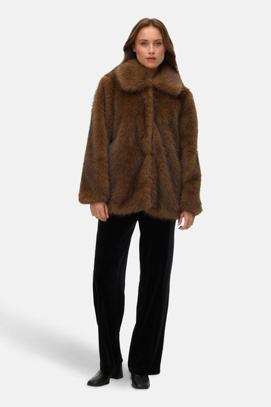 Bruine korte jas van VERO MODA, met kraag en gedragen over een zwarte velvet broek.
