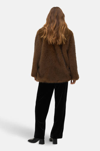 Bruine korte jas van VERO MODA®, op de rug gezien, met zwarte velvet broek en leren laarzen.