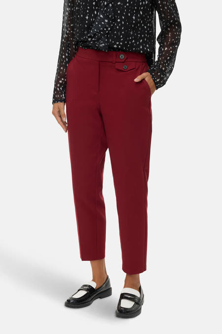 Jean rouge de VERO MODA®, associé à une blouse noire et blanche et des loafers noirs.