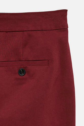 Rode broek van VERO MODA, met zakdetail en een zwarte knoop.