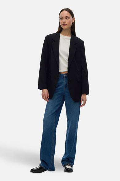 Zwarte blazer van VERO MODA, met lange mouwen, gedragen met een wit shirt en blauwe jeans.
