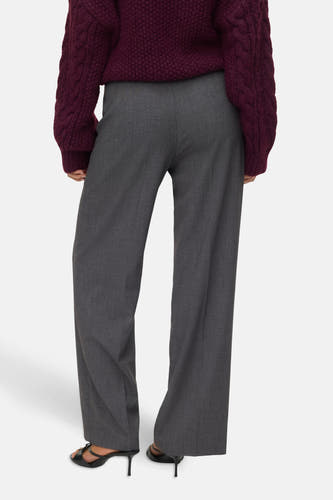 Pantalon gris de VERO MODA, avec des jambes larges et porté avec une chemise bordeaux et des baskets noires.
