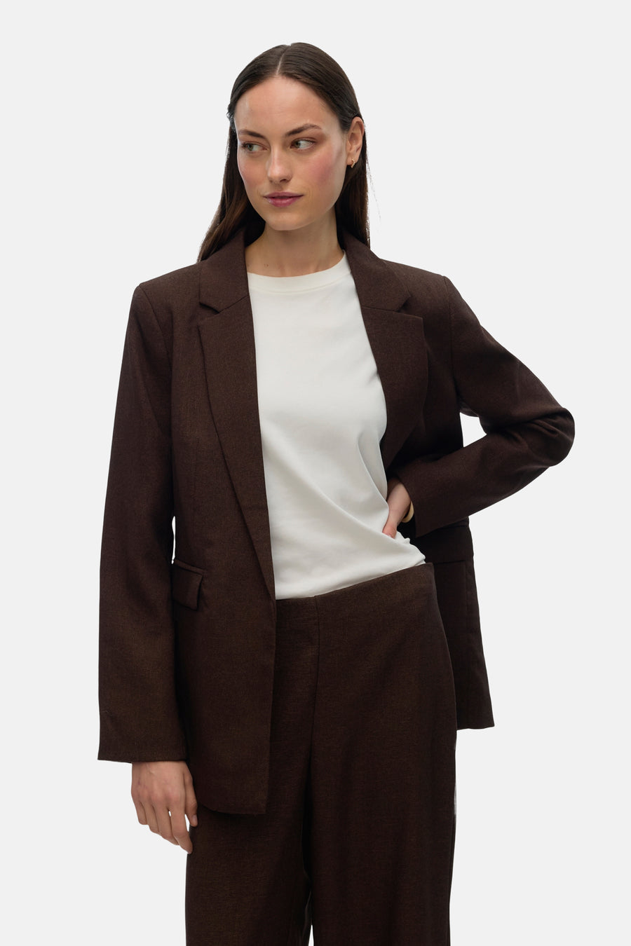 Vrouw met bruin pak en wit T-shirt.