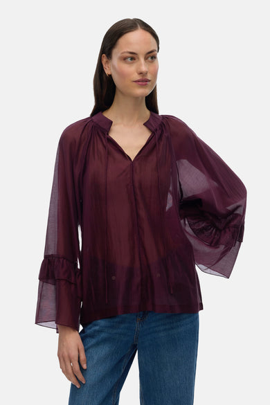 Bordeaux blouse met lange mouwen van VERO MODA, met ruches en gedragen met een blauwe jeans.
