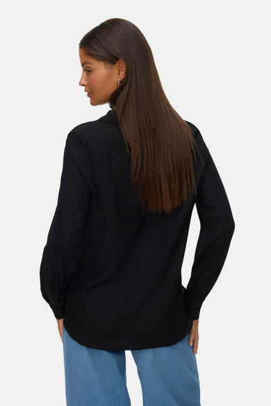 Zwart overhemd met lange mouwen van VERO MODA, gezien van achteren, gecombineerd met een blauwe broek.