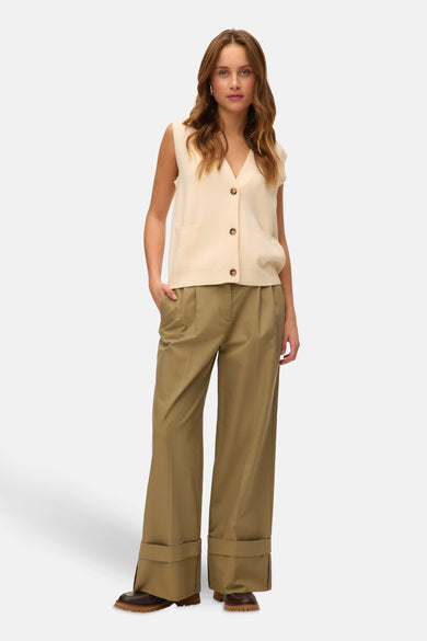 Beige gilet van Vero Moda, met knoopsluiting en opgestikte zakken, gedragen met kaki broek en bruine schoenen.