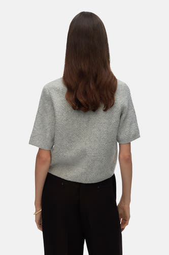 Grijs gilet van VERO MODA, gezien van achteren, met zwarte broek en een armband.
