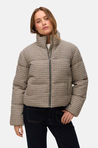 Beige korte jas van VERO MODA®, met een ruitjespatroon en gecombineerd met donkere jeans.
