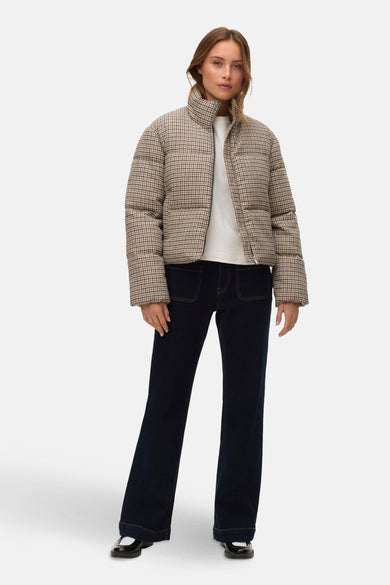 Beige korte jas van VERO MODA, met een ruitpatroon, gedragen met een wit T-shirt en donkere jeans.
