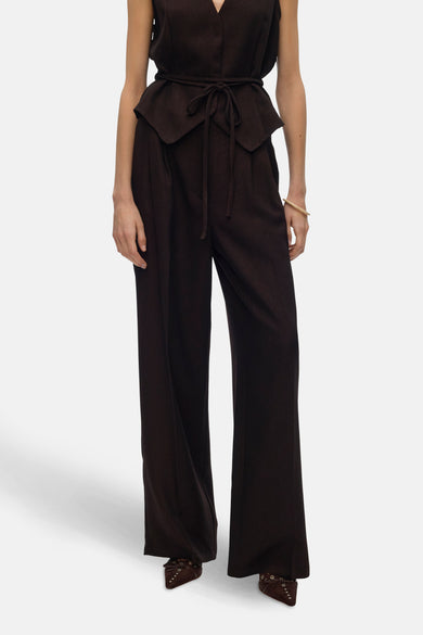Pantalon brun de VERO MODA, avec des jambes larges et une taille haute, associé à un gilet brun avec ceinture.