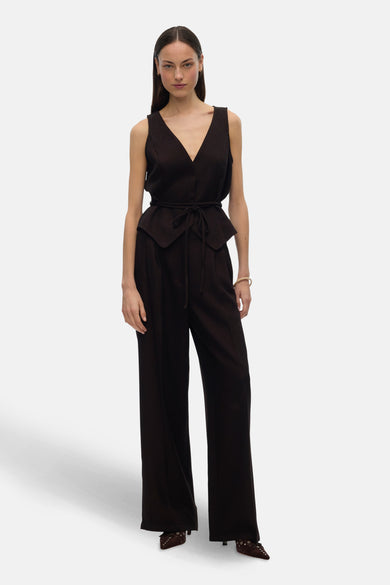Bruine broek van VERO MODA, met wijde pijpen en hoge taille, gecombineerd met een bruin vest met riem.
