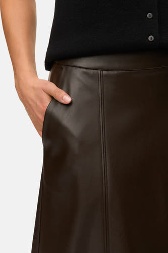 Lange bruine rok van VERO MODA, met een leren textuur en een hand in de zak.