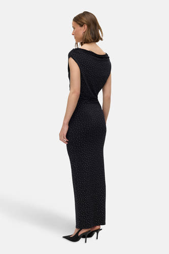 Robe sans manches noire de VERO MODA, avec de petits points blancs, longue et portée avec des escarpins noirs.