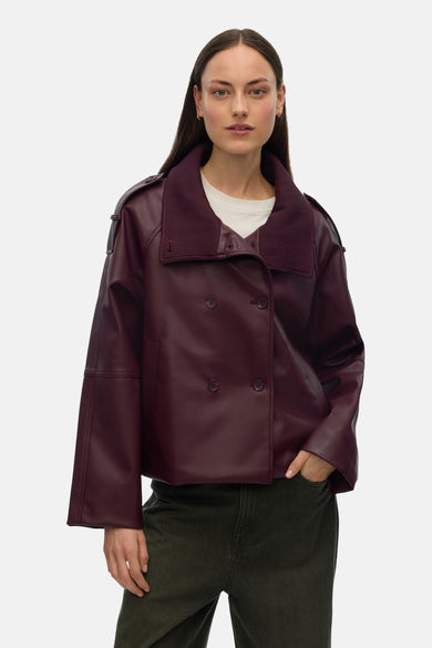 Paarse jas van VERO MODA met lange mouwen, een ribgebreide kraag en dubbele knopen, gedragen over een wit T-shirt met groene broek.
