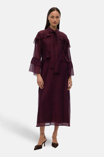 Paarse jurk met lange mouwen van VERO MODA, met ruches en strikdetail, gedragen met bruine muiltjes.
