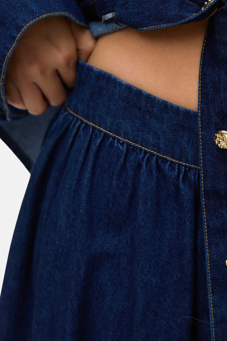 Donkerblauwe lange denim rok van VERO MODA met plooien en zichtbare goudkleurige knoop.