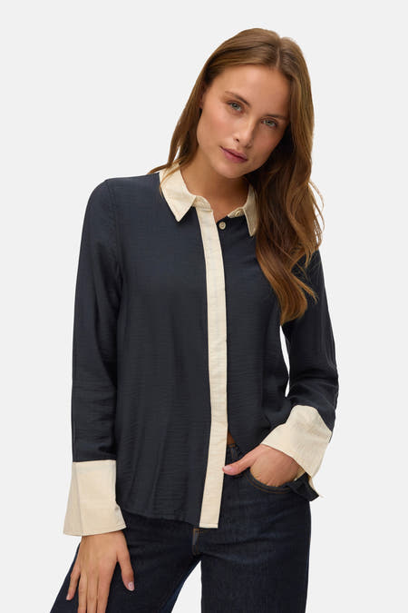 Zwart overhemd met lange mouwen van VERO MODA, met contrasterende kraag en manchetten, gedragen met een donkere jeans.