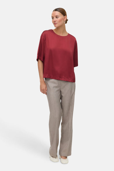 Rode blouse met korte mouwen van VERO MODA®, gedragen met een grijze pantalon en crèmekleurige ballerina's.