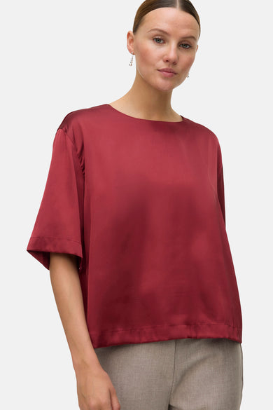 Rode blouse met korte mouwen van VERO MODA, effen en gedragen met een grijze pantalon.