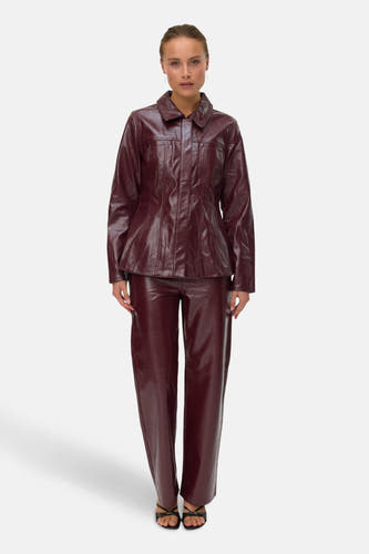 Bordeaux broek van VERO MODA, gedragen met een bijpassende jas en open hakken.
