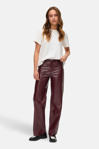 Bordeaux broek van VERO MODA, gecombineerd met een wit T-shirt en zwarte schoenen.