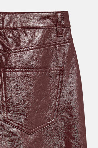 Bordeaux broek van VERO MODA, met een glanzende lakleren textuur en zichtbare achterzak.
