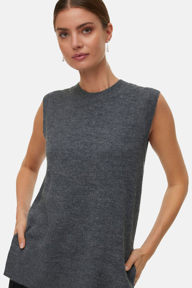 Grijs debardeur van VERO MODA, met fijne textuur en een ronde halslijn, gedragen met zilverkleurige oorbellen.
