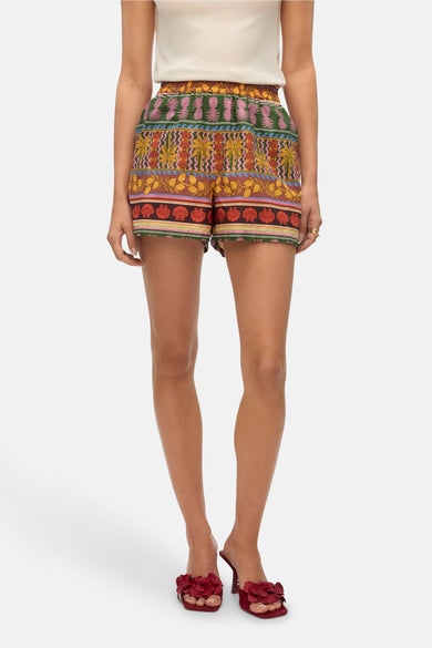 Multikleurige short van VERO MODA met tropische patronen en rode sandalen.
