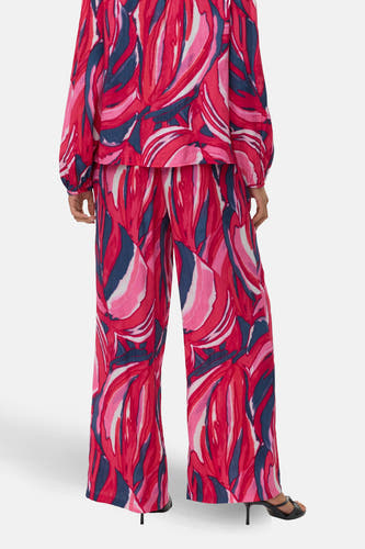 Multikleurige broek van Vero Moda met een abstract bladpatroon en wijde pijpen, gezien van achteren.
