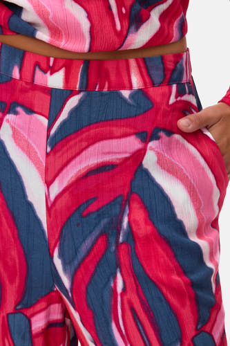 Multikleurige broek van VERO MODA, met abstract bladpatroon en hand in de zak.