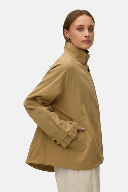 Beige korte jas van VERO MODA, met hoge kraag en steekzak, in zijaanzicht.