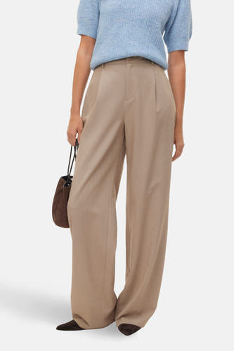 Beige broek van VERO MODA, met wijde pijpen en een bruine handtas.
