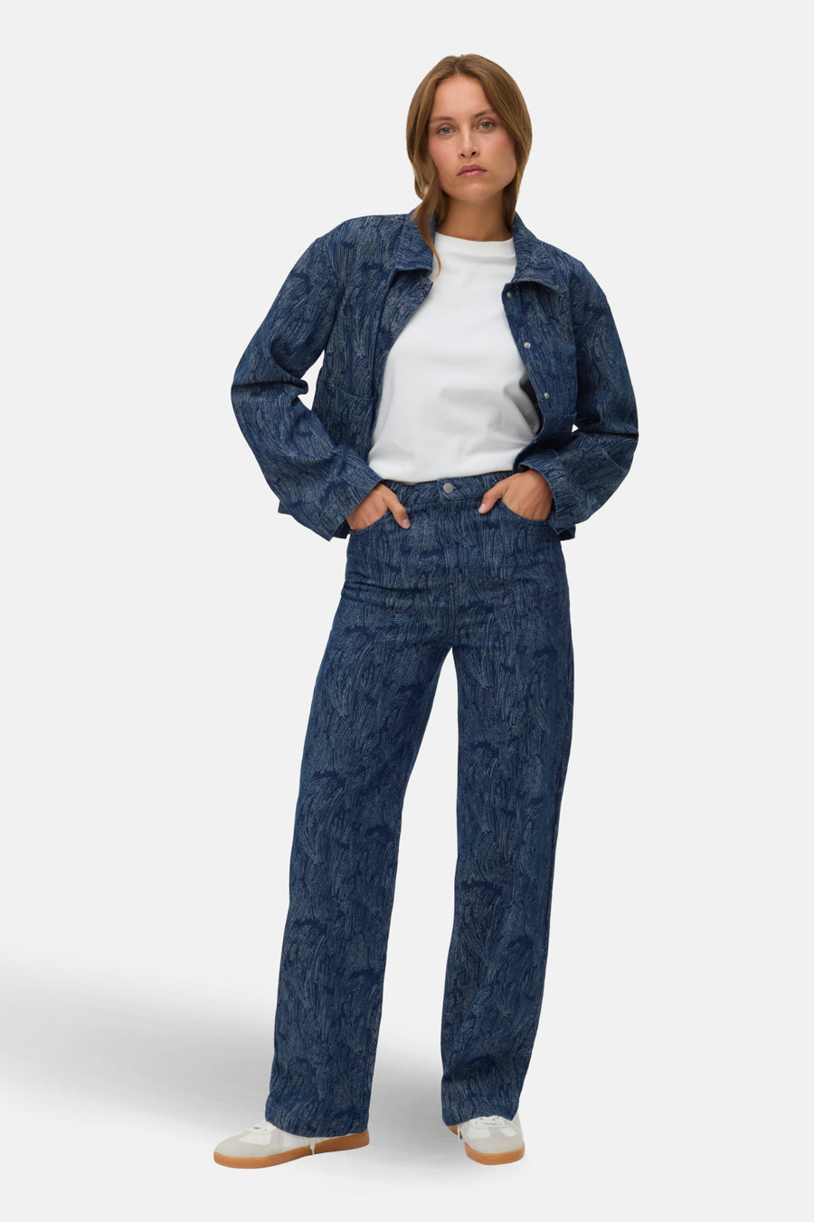 Wijde jeans van donkerblauw denim van VERO MODA, met een patroon, gecombineerd met een wit shirt en een spijkerjasje.