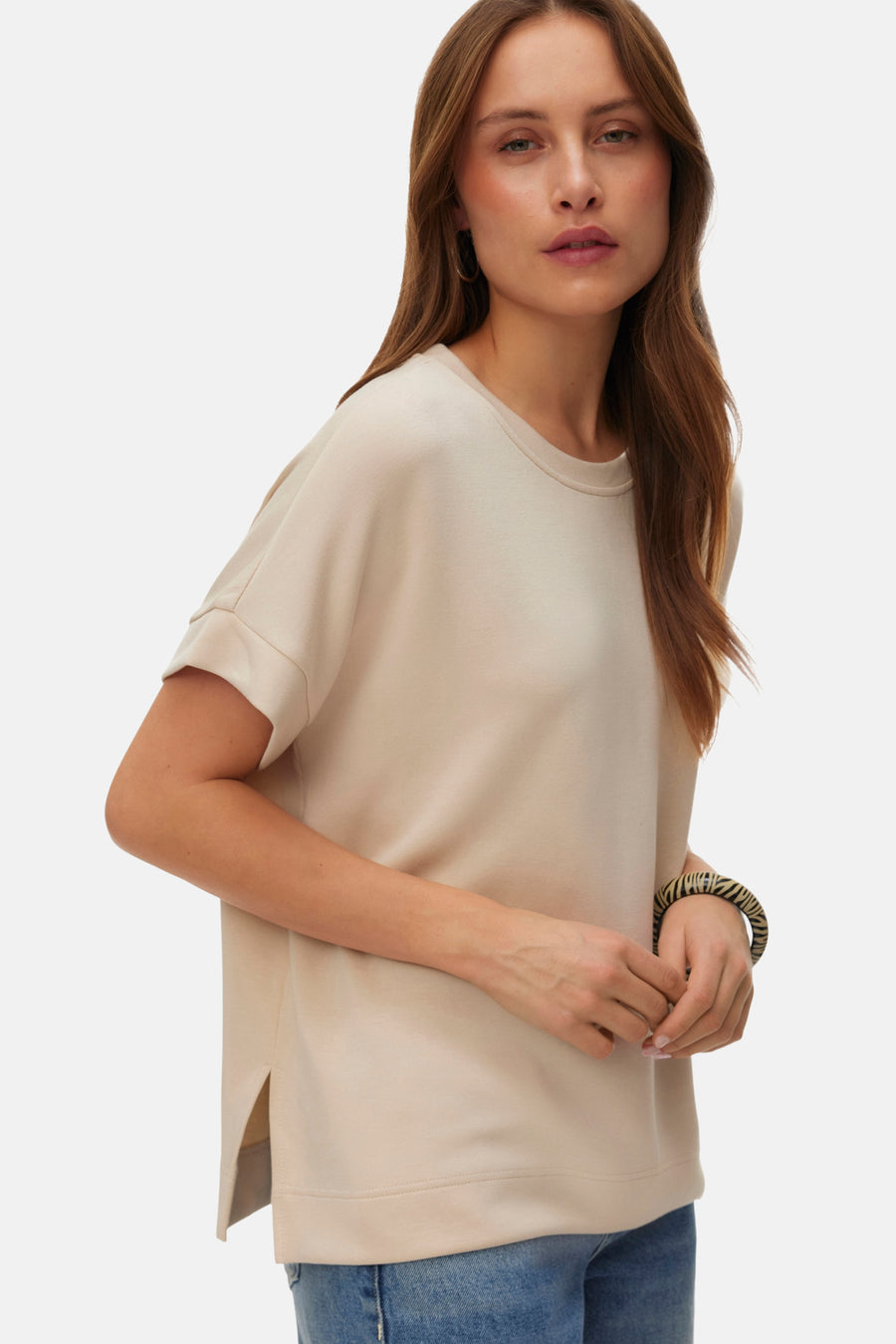 T-shirt écru à manches courtes de VERO MODA, porté avec des jeans larges et des chaussures noires.