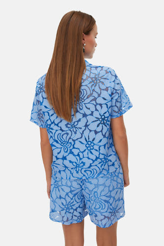Blauw hemd met korte mouwen van VERO MODA met bloemenkantpatroon, gedragen met bijpassende shorts, achteraanzicht.