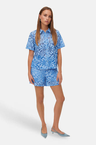 Blauwe shorts van VERO MODA met een opengewerkt bloemenpatroon, gedragen als een set met een overhemd.
