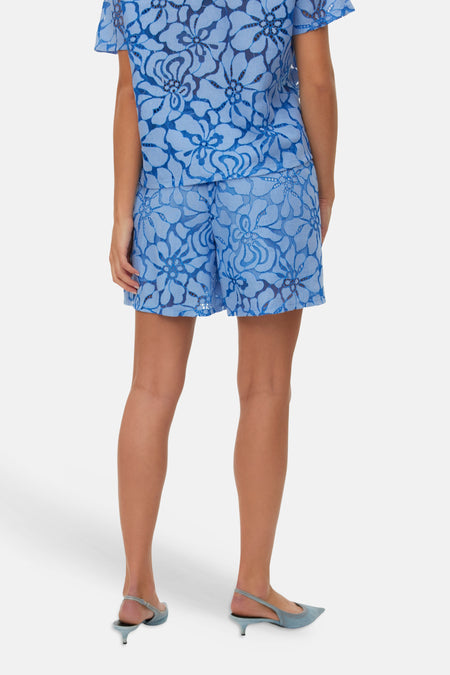 Blauwe kanten short van VERO MODA met open bloemenpatroon, gecombineerd met bijpassende top en lichtblauwe muiltjes.