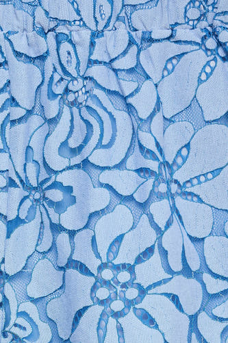 Detail van een lichtblauwe short van VERO MODA met een kanten bloemenpatroon.