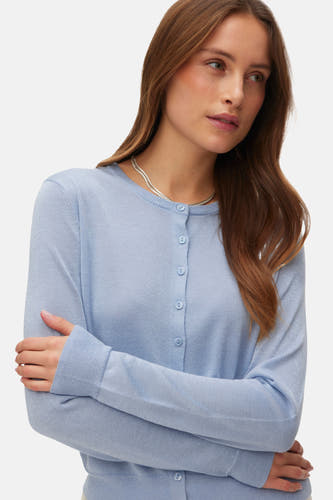 Blauwe cardigan van VERO MODA, met lange mouwen en knoopsluiting, gedragen met een zilveren ketting.

