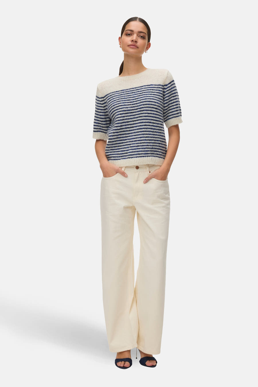Blauwe trui met ronde hals van VERO MODA, met horizontale strepen, gedragen met een crèmekleurige broek.
